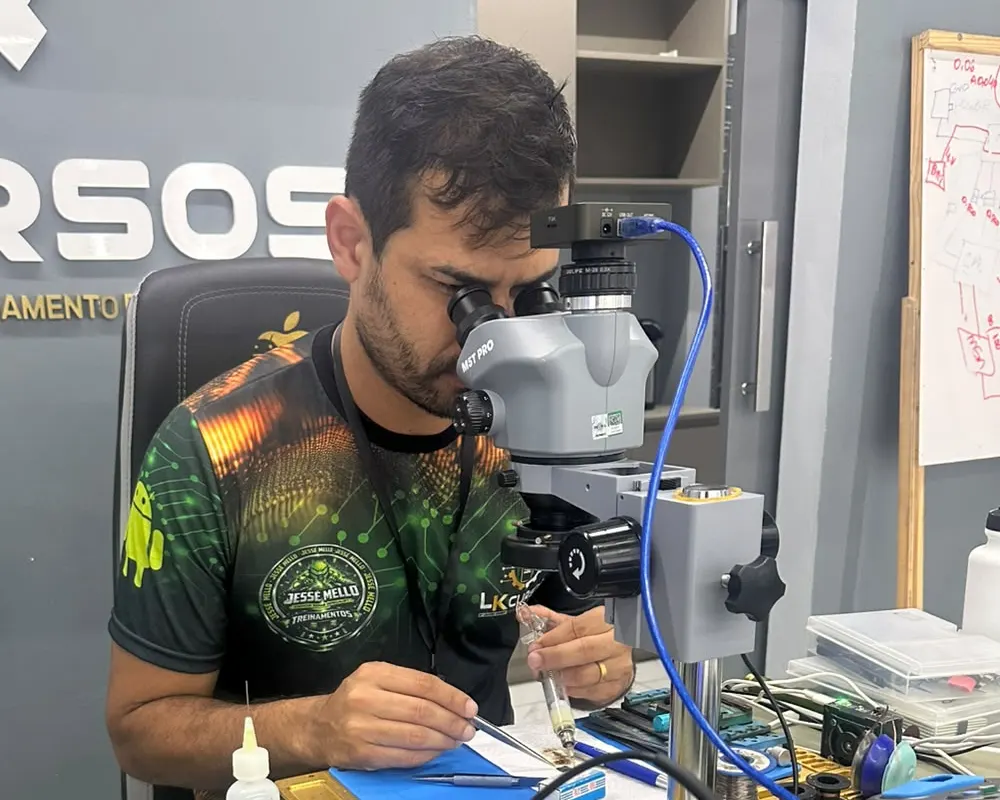 Alaf, técnico da Alafcell, trabalhando em placa de celular no microscópio durante o curso